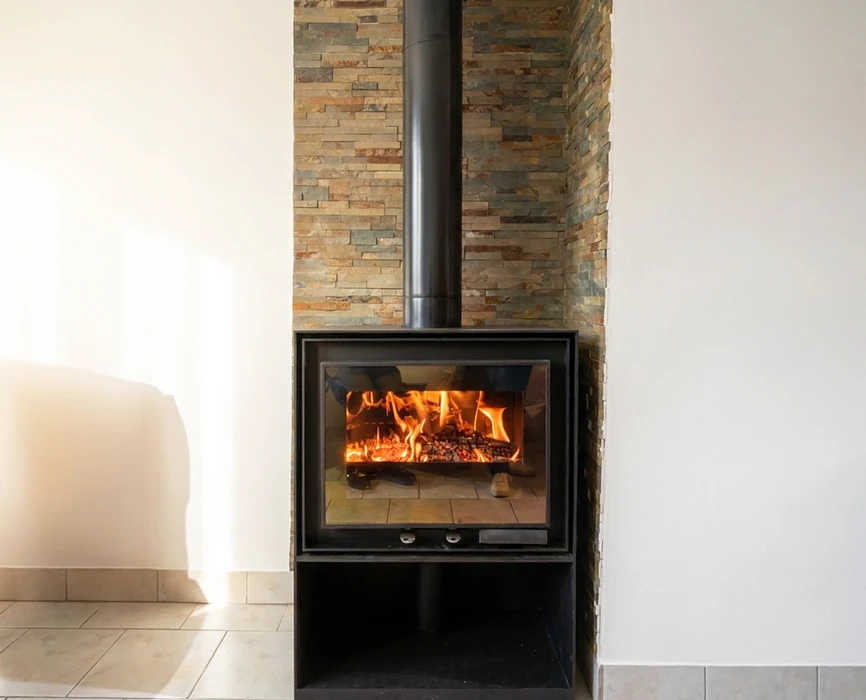 Intérieur moderne avec un poêle à bois encastré dans un habillage en pierre de parement multicolore