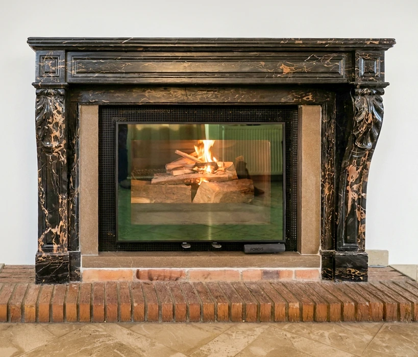 Cheminée en marbre noir veiné or de style classique, avec consoles sculptées en forme de volutes