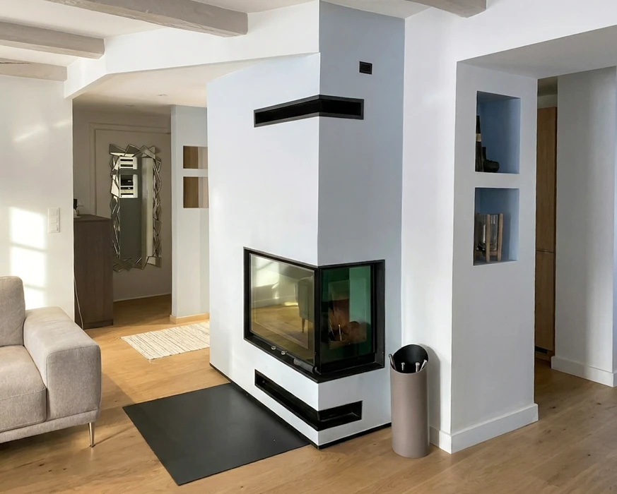 Salon moderne avec cheminée encastrée double-face à foyer fermé, vitrage panoramique d'angle, habillage en stuc blanc et encadrements noirs