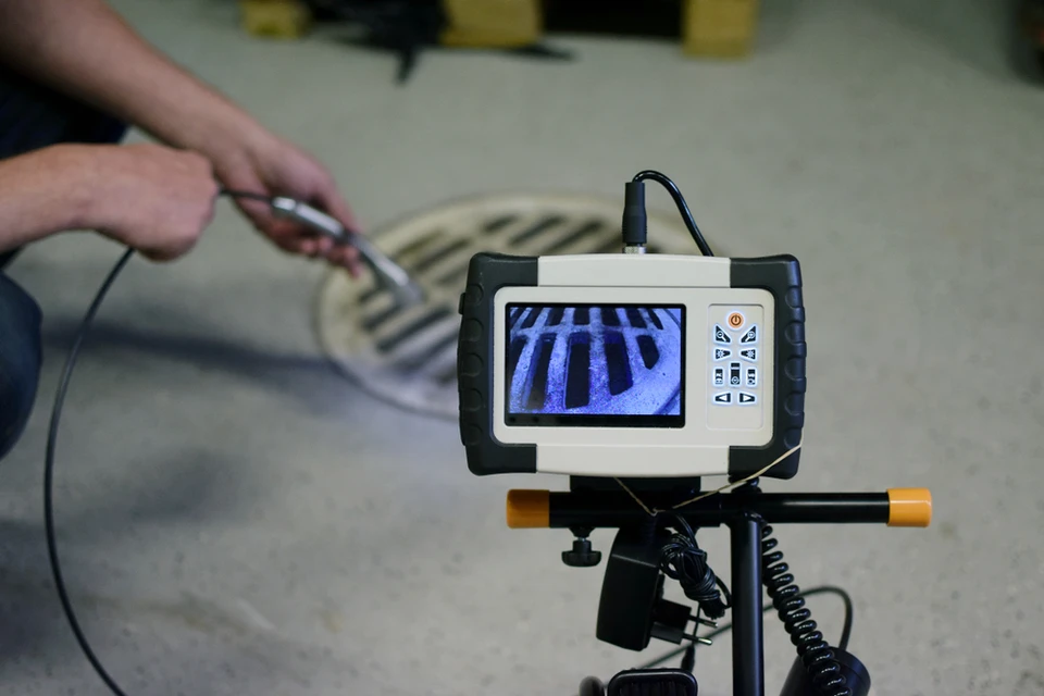 Intérieur d'atelier, technicien manipulant une sonde d'inspection reliée à un équipement de contrôle