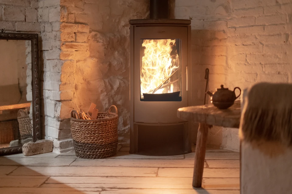 Intérieur chaleureux avec poêle à bois moderne en fonctionnement, flammes visibles à travers la vitre