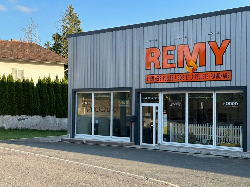 Ouvrier ramoneur équipé d'un hérisson de ramonage travaillant sur toiture en tuiles mécaniques rouges, cheminée maçonnée visible