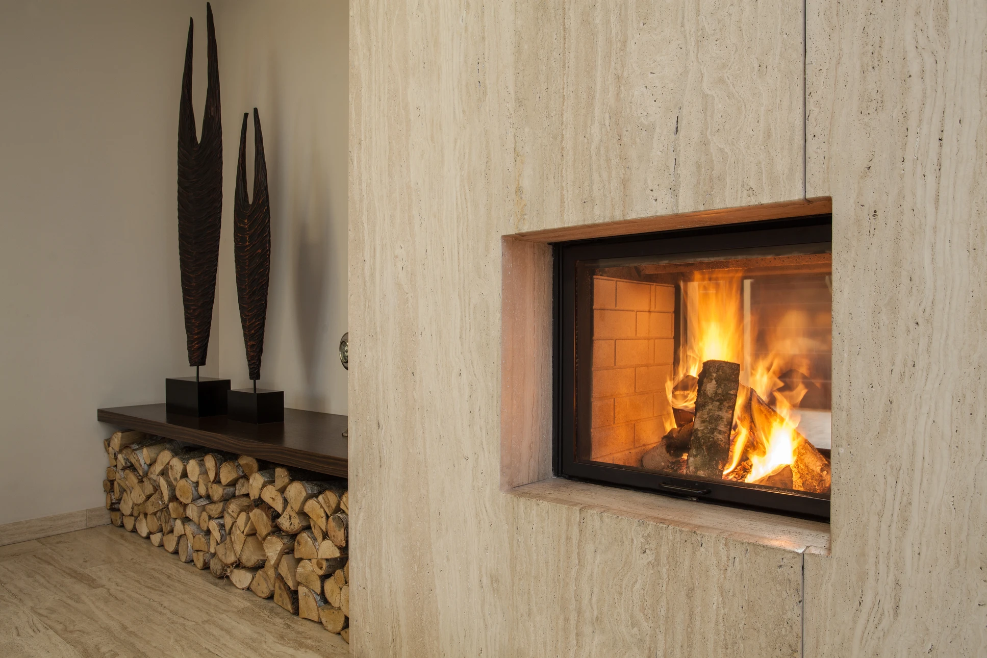 Intérieur chaleureux avec poêle à bois en fonte noire allumé, flammes visibles à travers vitre ornementée