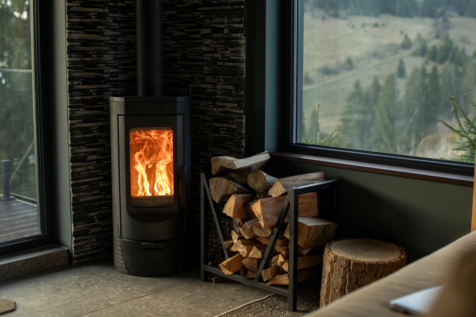 Intérieur moderne avec poêle à bois central en fonctionnement, flammes visibles